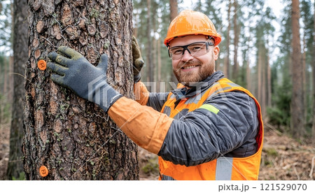 Smiling Logger in Forest with Safety Gear and Tools 121529070