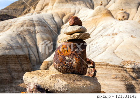 Stack of bright balancing rocks in badland canyon in summer. Stack of bright balancing rocks in badland canyon in summer. 121531145