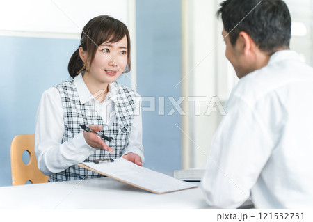 接客・顧客対応する受付嬢・事務員の女性と顧客の男性 121532731