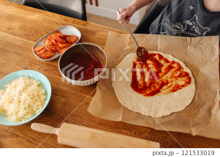 little girl making pizza dough on wooden tabletop in kitchen little girl making pizza dough on wooden tabletop in kitchen 121533019
