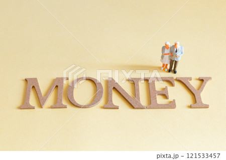 お金のイメージ シニアカップルのミニチュア人形とMONEYという文字 お金のイメージ シニアカップルのミニチュア人形とMONEYという文字 121533457