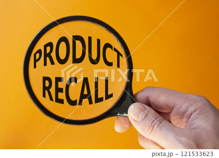 Product recall symbol. Concept words Product recall on magnifying glass. Beautiful orange background. Businessman hand. Business and Product recall concept. Copy space. 121533623