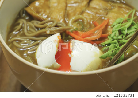 和風カレー蕎麦、半熟卵と油揚げをトッピングした、アツアツの食べ物 121533731