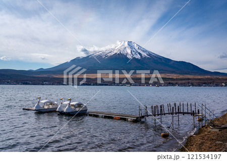 View of mount Fuji with background clouds and paddle swan boats at lake Kawaguchiko in foreground 121534197