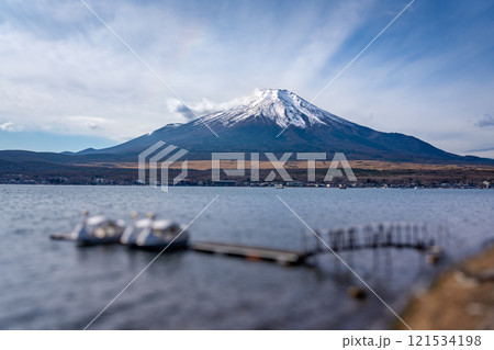 View of mount Fuji with background clouds and paddle swan boats at lake Kawaguchiko in foreground 121534198
