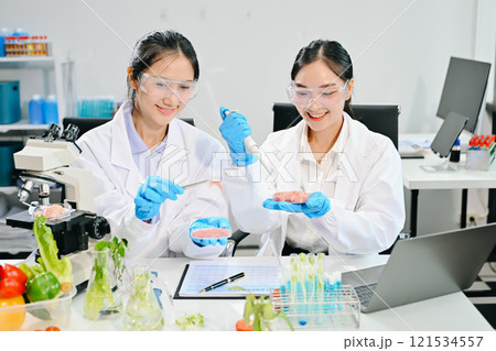 Food scientists in lab coats, testing samples, and analyzing food safety and quality 121534557