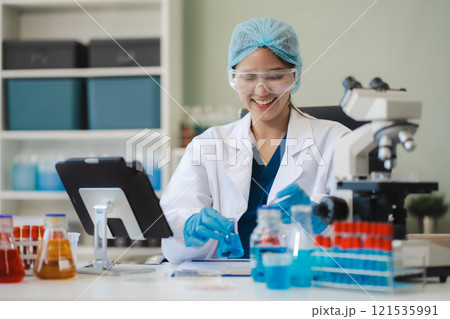 Chemist scientist holding test tube and tablet conducting experiment in laboratory with equipment, science concept. 121535991