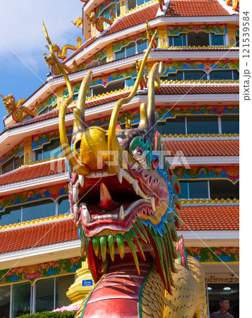 Close-up of colorful dragon decorations on a blue sky background at a Thai temple. Close-up of colorful dragon decorations on a blue sky background at a Thai temple. 121539584