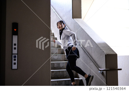 エレベーターより階段を選んで走る女性　トレーニング　ダイエット　運動　 121540364