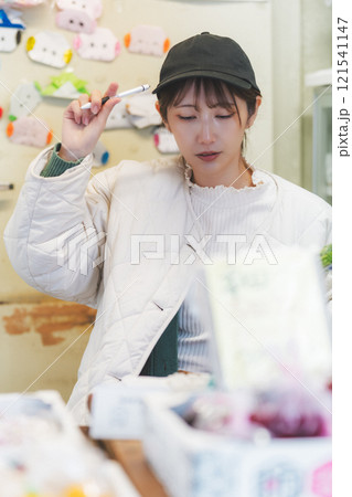 昔ながらの青果物店で店番する若い女性店員【撮影協力・沼垂テラス商店街】 昔ながらの青果物店で店番する若い女性店員【撮影協力・沼垂テラス商店街】 121541147