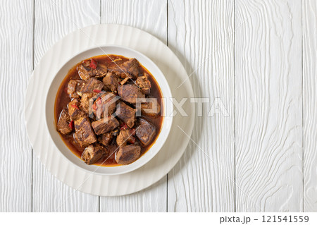 beef stew in a white bowl on rustic wooden table 121541559