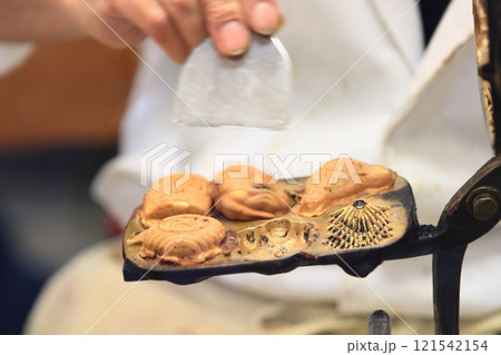 人形焼きを作る職人の手　手作りの人形焼き 121542154