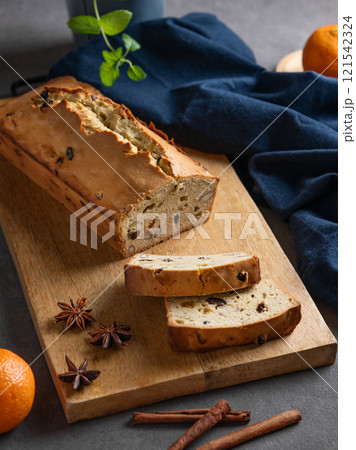 Spicy pie with fruits, nuts and spices on a wooden board, on a dark background 121542324