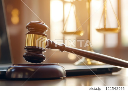 A judge's gavel sits on a wooden podium in front of a laptop A judge's gavel sits on a wooden podium in front of a laptop 121542963