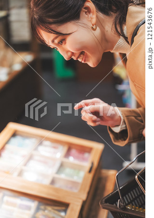 昔ながらの駄菓子屋で懐かしく買い物をする若い女性【撮影協力・お米・駄菓子屋 加賀田米穀店】 121543676