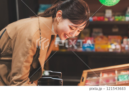 昔ながらの駄菓子屋で懐かしく買い物をする若い女性【撮影協力・お米・駄菓子屋 加賀田米穀店】 121543683