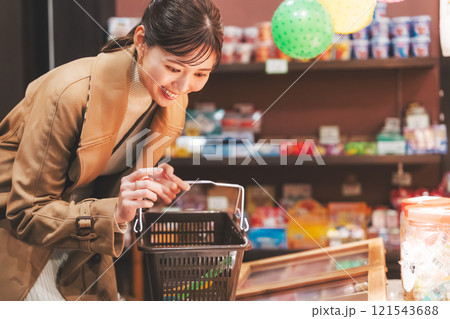 昔ながらの駄菓子屋で懐かしく買い物をする若い女性【撮影協力・お米・駄菓子屋 加賀田米穀店】 121543688