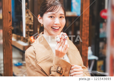 昔ながらの駄菓子屋で懐かしく買い物をする若い女性【撮影協力・お米・駄菓子屋 加賀田米穀店】 121543693