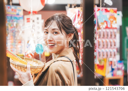 昔ながらの駄菓子屋で懐かしく買い物をする若い女性【撮影協力・お米・駄菓子屋 加賀田米穀店】 昔ながらの駄菓子屋で懐かしく買い物をする若い女性【撮影協力・お米・駄菓子屋 加賀田米穀店】 121543706