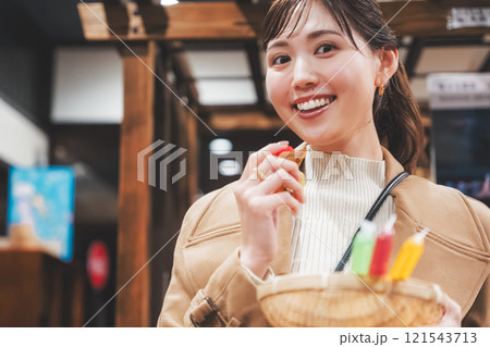 昔ながらの駄菓子屋で懐かしく買い物をする若い女性【撮影協力・お米・駄菓子屋 加賀田米穀店】 121543713