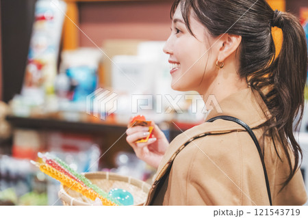 昔ながらの駄菓子屋で懐かしく買い物をする若い女性【撮影協力・お米・駄菓子屋 加賀田米穀店】 昔ながらの駄菓子屋で懐かしく買い物をする若い女性【撮影協力・お米・駄菓子屋 加賀田米穀店】 121543719