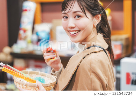 昔ながらの駄菓子屋で懐かしく買い物をする若い女性【撮影協力・お米・駄菓子屋 加賀田米穀店】 昔ながらの駄菓子屋で懐かしく買い物をする若い女性【撮影協力・お米・駄菓子屋 加賀田米穀店】 121543724