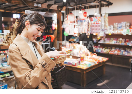 昔ながらの駄菓子屋で懐かしく買い物をする若い女性【撮影協力・お米・駄菓子屋 加賀田米穀店】 昔ながらの駄菓子屋で懐かしく買い物をする若い女性【撮影協力・お米・駄菓子屋 加賀田米穀店】 121543730