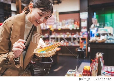 昔ながらの駄菓子屋で懐かしく買い物をする若い女性【撮影協力・お米・駄菓子屋 加賀田米穀店】 昔ながらの駄菓子屋で懐かしく買い物をする若い女性【撮影協力・お米・駄菓子屋 加賀田米穀店】 121543732