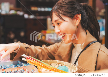 昔ながらの駄菓子屋で懐かしく買い物をする若い女性【撮影協力・お米・駄菓子屋 加賀田米穀店】 昔ながらの駄菓子屋で懐かしく買い物をする若い女性【撮影協力・お米・駄菓子屋 加賀田米穀店】 121543746