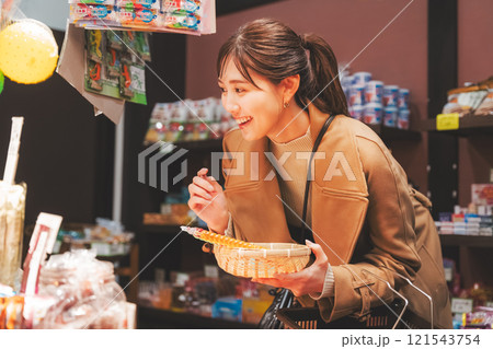 昔ながらの駄菓子屋で懐かしく買い物をする若い女性【撮影協力・お米・駄菓子屋 加賀田米穀店】 昔ながらの駄菓子屋で懐かしく買い物をする若い女性【撮影協力・お米・駄菓子屋 加賀田米穀店】 121543754