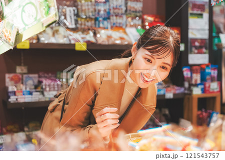 昔ながらの駄菓子屋で懐かしく買い物をする若い女性【撮影協力・お米・駄菓子屋 加賀田米穀店】 121543757