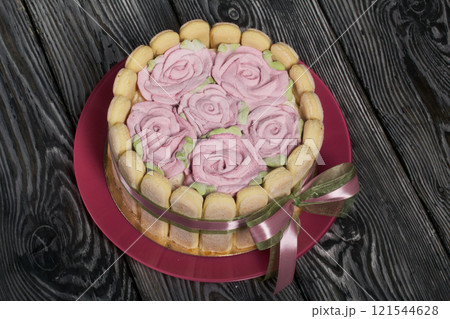 Cake with Savoiardi cookies and marshmallow roses. Tied with ribbon. The ribbon is tied into a bow. 121544628