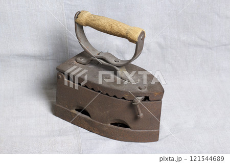 Old iron, heated by hot coals. Located on linen fabric. 121544689