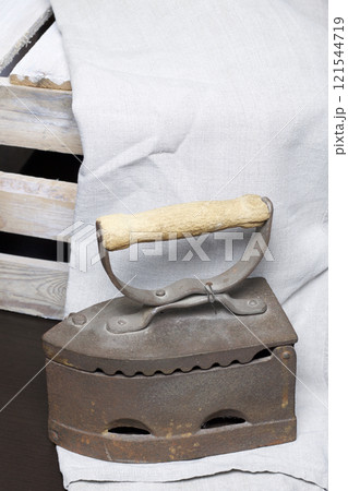 Old iron, heated by hot coals. Standing next to a wooden box. 121544719