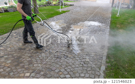 Professional cleaning service worker washing cobblestone 121546023