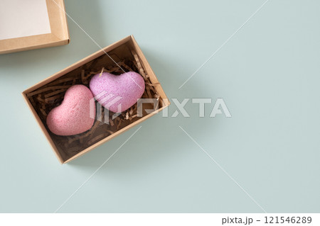 Valentine's Day two heart shaped bathroom bombs in natural gift box on blue background. Handmade bathroom bombs in heart-shaped gift box. Natural cosmetics. Concept of therapy. Home spa products. Valentine's Day two heart shaped bathroom bombs in natural gift box on blue background. Handmade bathroom bombs in heart-shaped gift box. Natural cosmetics. Concept of therapy. Home spa products. 121546289