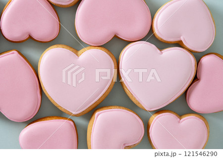 Valentine's Day heart shaped pink glazed cookies on blue background. View from above. Abstract food pattern. Valentine's Day heart shaped pink glazed cookies on blue background. View from above. Abstract food pattern. 121546290