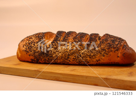 Wooden bamboo board, white bread with poppy seed filling and poppy seed topping Wooden bamboo board, white bread with poppy seed filling and poppy seed topping 121546333