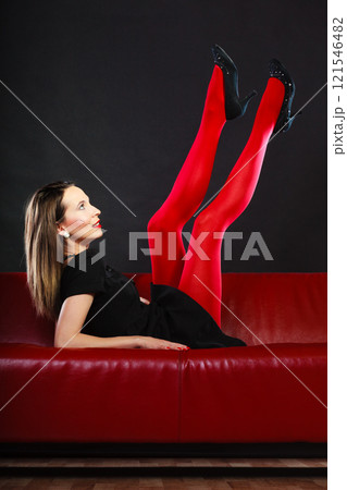 Fashion woman in red pantyhose on couch 121546482