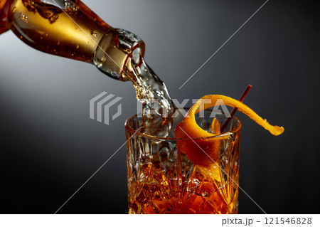 Whiskey or bourbon pouring into a crystal glass. 121546828