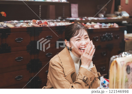 昔ながらの駄菓子屋で懐かしく買い物をする若い女性【撮影協力・お米・駄菓子屋 加賀田米穀店】 121546998