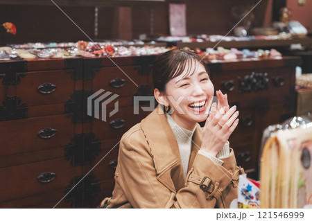昔ながらの駄菓子屋で懐かしく買い物をする若い女性【撮影協力・お米・駄菓子屋 加賀田米穀店】 121546999