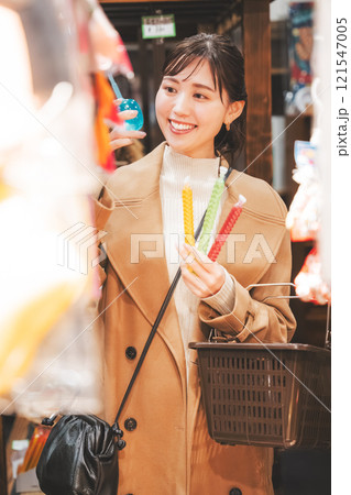 昔ながらの駄菓子屋で懐かしく買い物をする若い女性【撮影協力・お米・駄菓子屋 加賀田米穀店】 昔ながらの駄菓子屋で懐かしく買い物をする若い女性【撮影協力・お米・駄菓子屋 加賀田米穀店】 121547005