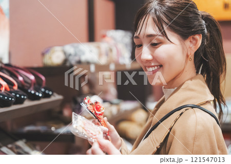 昔ながらの駄菓子屋で懐かしく買い物をする若い女性【撮影協力・お米・駄菓子屋 加賀田米穀店】 昔ながらの駄菓子屋で懐かしく買い物をする若い女性【撮影協力・お米・駄菓子屋 加賀田米穀店】 121547013