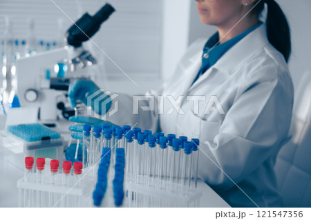 A scientist is meticulously analyzing various samples under a highpowered microscope in a stateoftheart modern laboratory, utilizing advanced technology to gain insights into biological processes 121547356