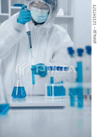 Laboratory Research Focus A Professional Scientist in Protective Gear, Diligently Conducts an Experiment Using a Pipette to Ensure Accuracy and Precision in Scientific Research and Innovation 121547373