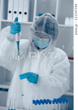 A skilled Laboratory Scientist is meticulously conducting precise liquid handling using a pipette, showcasing their expertise in biotechnology and chemistry in a research environment 121547394