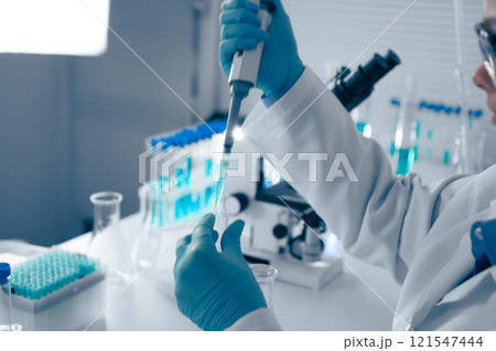 A skilled Laboratory Scientist expertly uses a pipette, an essential tool for precise liquid handling in experiments, ensuring accurate measurements for reliable results in research and testing A skilled Laboratory Scientist expertly uses a pipette, an essential tool for precise liquid handling in experiments, ensuring accurate measurements for reliable results in research and testing 121547444