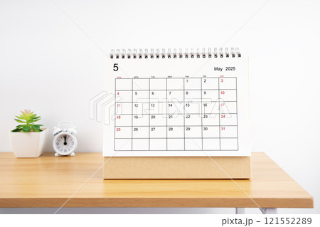 May 2025, Monthly desk calendar for 2025 year on wooden table. 121552289