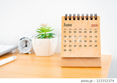 June 2025 desk calendar on worktable. 121552374
